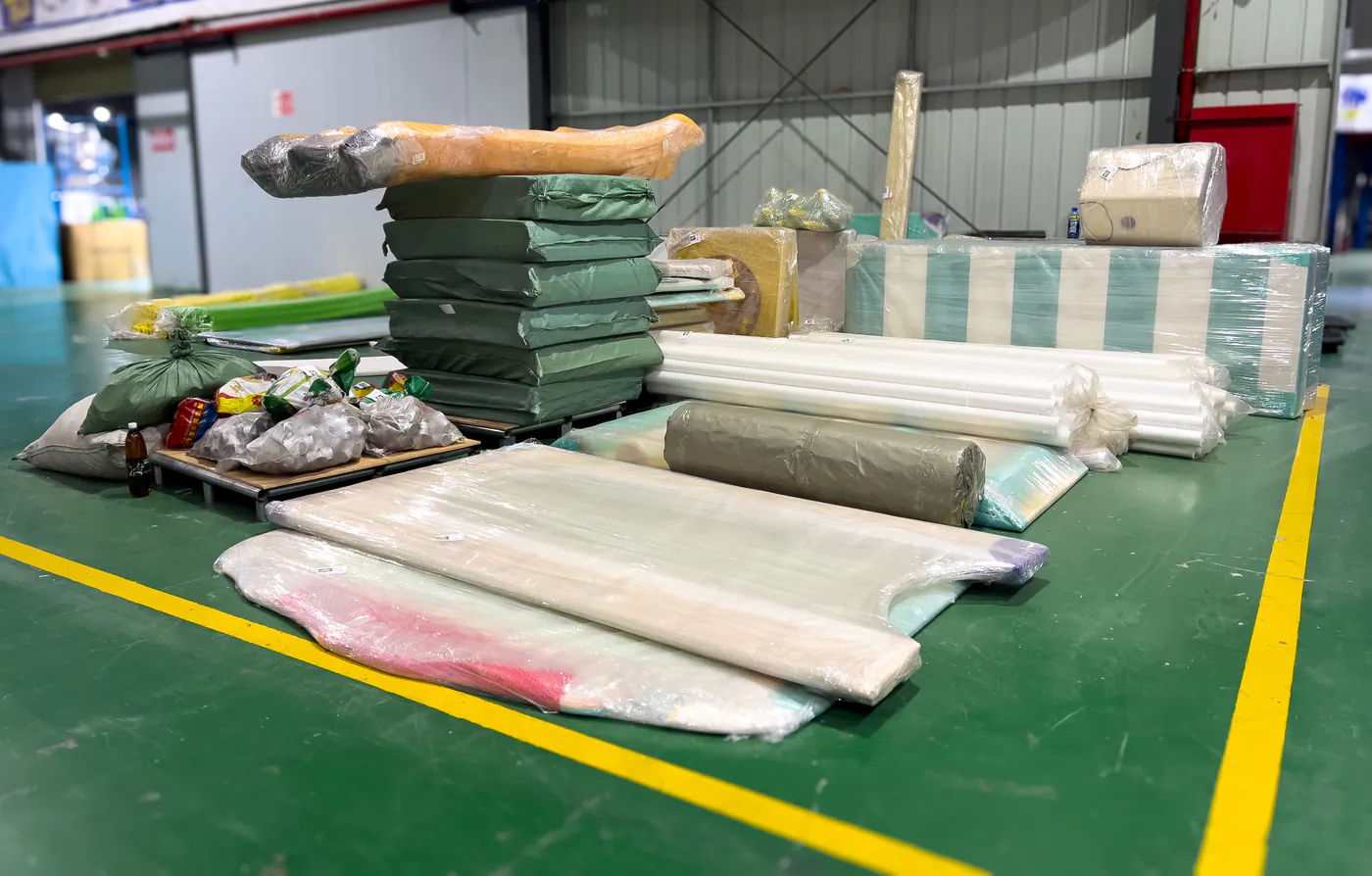 Wrapped playground components and packing materials on a workshop table